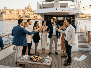 Group celebrating on Malta event boat at sunset